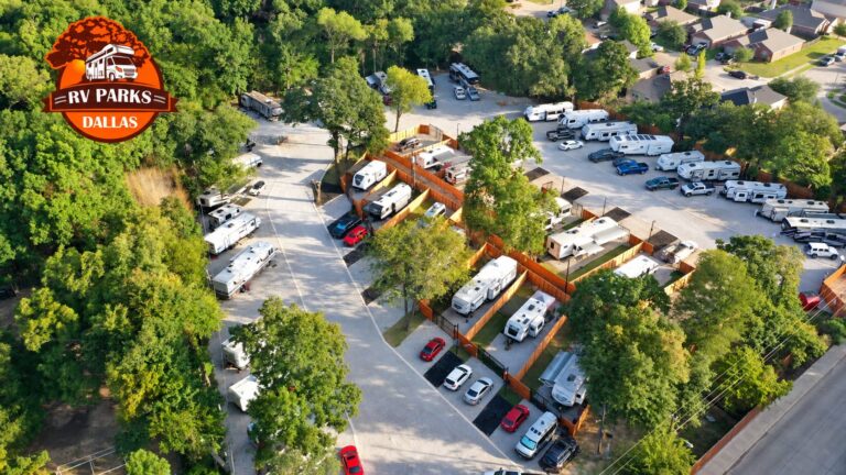 Drone view of RVs parked in private fenced lots surrounded by trees at Dallas Shady Oaks RV Park